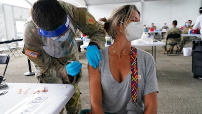 Liana Fonseca looks away as she receives the Pfizer COVID-19 vaccine in Miami, March 9, 2021.