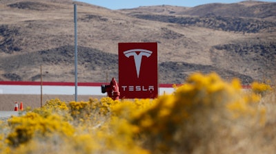 In this Oct. 13, 2018, file photo, a sign marks the entrance to the Tesla Gigafactory in Sparks, Nev. A Russian citizen has pleaded guilty to offering a Tesla employee $1 million to get malware into the electric car company's plant in Nevada and enable a ransomware attack. Attorneys representing Egor Igorevich Kriuchkov did not immediately respond Friday, March 19, 2021, to messages about his Thursday plea in U.S. District Court in Reno.