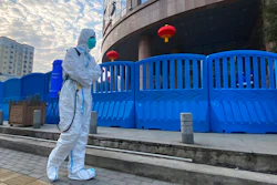 A worker carrying disinfecting equipment walks outside the Wuhan Central Hospital, Wuhan, China, Feb. 6, 2021.
