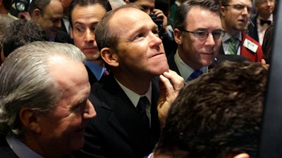 In this Jan. 26, 2011 file photo, Nielsen Company CEO David Calhoun, center, watches progress as he waits for the company's IPO to begin trading, on the floor of the New York Stock Exchange. Boeing CEO David Calhoun declined a salary and performance bonus for most of 2020 but still received stock benefits that pushed the estimated value of his compensation to more than $21 million, according to a regulatory filing Friday, March 5, 2021.