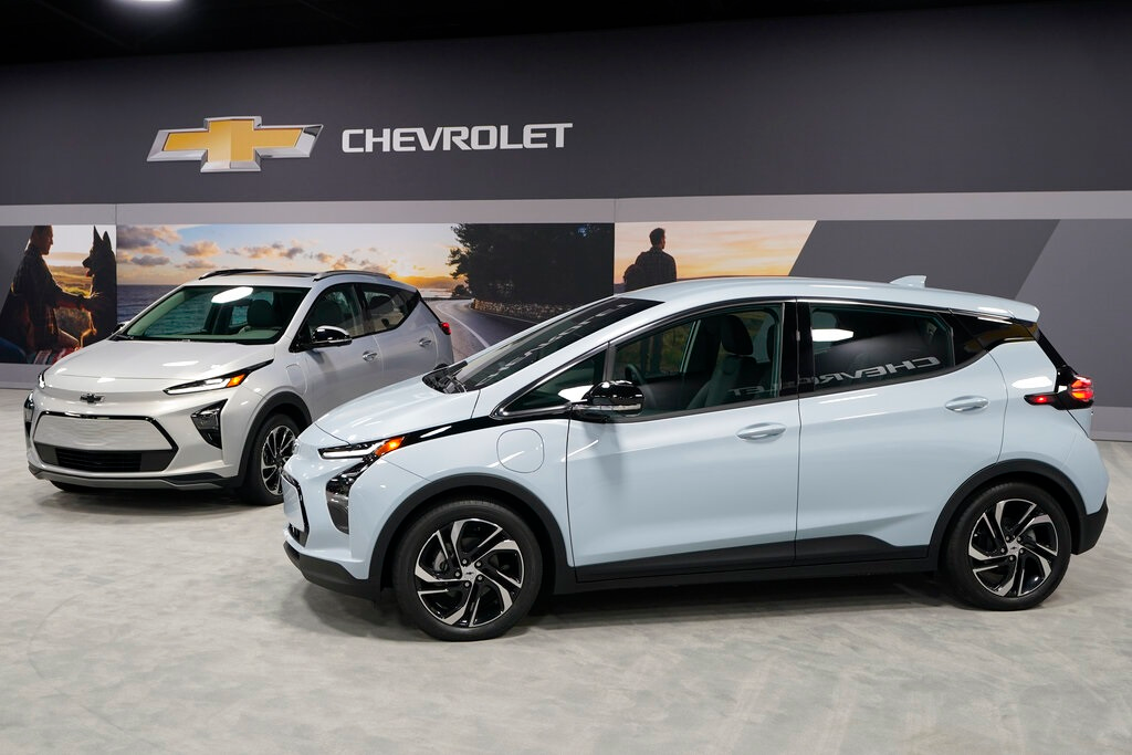 The 2022 Bolt EV, foreground, and EUV are displayed, Thursday, Feb. 11, 2021, in Milford, Mich. Whether people want them or not, automakers are rolling out multiple new electric vehicle models as the auto industry responds to stricter pollution regulations worldwide and calls to reduce emissions to fight climate change.