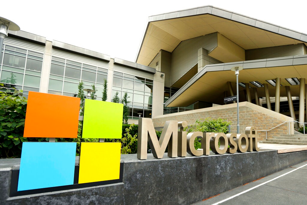 In this July 3, 2014, file photo, the Microsoft Corp. logo is displayed outside the Microsoft Visitor Center in Redmond, Wash. Microsoft will begin bringing workers back to its suburban Seattle global headquarters on March 29, 2021, as the tech giant starts to reopen more facilities it largely shuttered during the coronavirus pandemic.