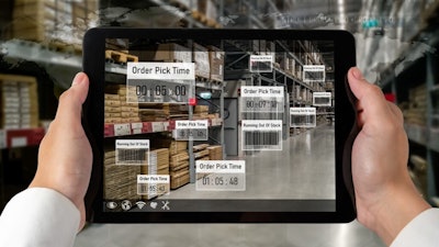 Person holding iPad looking at warehouse.