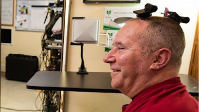 A participant in the BrainGate clinical trial uses wireless transmitters that replace the cables normally used to transmit signals from sensors inside the brain.