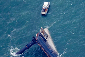 A rescue boat is seen next to the capsized lift boat Seacor Power seven miles off the coast of Louisiana in the Gulf of Mexico Sunday, April 18, 2021. The vessel capsized during a storm on Tuesday.