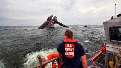 A Coast Guard Response Boat searches for survivors near the capsized SeaCor Power, an oil industry vessel.