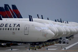 In this May 14, 2020 file photo, several dozen mothballed Delta Air Lines jets are parked on a closed runway at Kansas City International Airport in Kansas City, Mo. Delta Air Lines says it lost $1.2 billion in the first quarter, but the airline thinks it can by profitable by late summer unless there's a resurgence of COVID-19. Delta reported the results on Thursday, April 15, 2021.