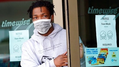 A man leaves a convenience store while wearing a required face mask in Houston, in this Thursday, June 25, 2020, file photo. Although nearly a fifth of U.S. states don't require people to wear masks to protect against COVID-19, some businesses are requiring employees and customers to be masked on their premises.