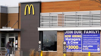 In this Nov. 19, 2020, file photo, a hiring sign is displayed outside of McDonald's in Buffalo Grove, Ill. On Wednesday, April 14, 2021, McDonald’s said the company will mandate worker training to combat harassment, discrimination and violence in its restaurants worldwide starting in 2022.