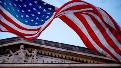 In this March 22, 2019 file photo, an American flag flies outside the Department of Justice in Washington. The Justice Department has assembled a task force to confront ransomware after what officials say was the most costly year on record for the crippling cyberattacks.
