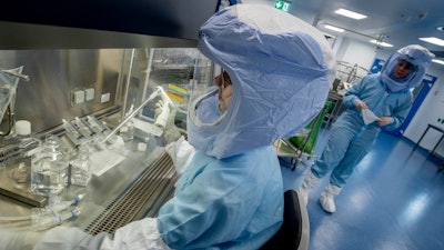Vaccine production staff demonstrate operations at a facility in Germany.