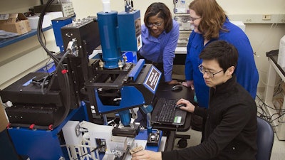Tahira Reid Smith (left) works with colleagues using an infrared microscope to study how heat affects hair.