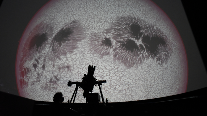 Researcher Ivannia Calvo, silhouetted against a solar satellite image, works inside the Solar Astronomical Observatory in San Jose, Costa Rica, April 30, 2021.