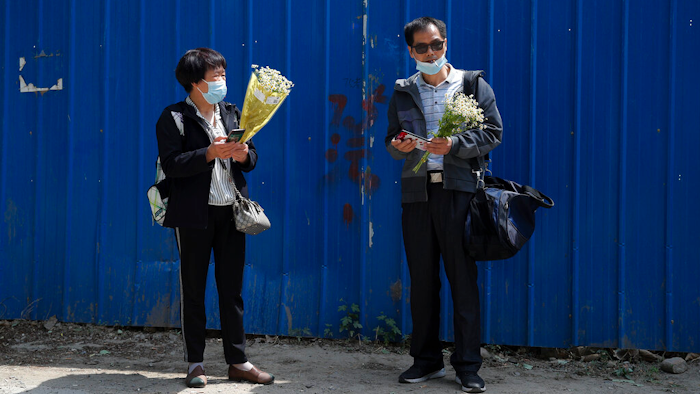 Wei Xiuwen, left, mother of Chen Mei, chats with Cai Jianli, father of Cai Wei, outside a courthouse in Beijing, May 11, 2021.