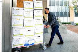 A member of Apple's legal team rolls exhibit boxes into the Ronald V. Dellums building in Oakland, Calif., May 3, 2021.
