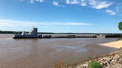 A tugboat with a barge attached sits near a boat ramp at Meeman-Shelby Forest State Park, Wednesday, May 12, 2021, in Millington, Tenn. A crack in the Interstate 40 bridge linking Tennessee and Arkansas has shut down Mississippi River traffic near Memphis, forcing tugs that are hauling barges to wait until they receive clearance that it's safe to pass under the closed bridge.