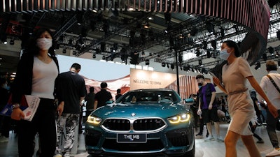 In this Sept. 27, 2020 file photo, visitors gather near a BMW M8 model on display at the Auto China 2020 show in Beijing, China. Booming sales in China helped propel German luxury carmaker BMW to stronger profits in the first three months of the year even as its home market Germany trailed the ongoing recovery in global car markets from the worst of the pandemic shutdowns.