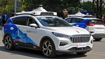 Baidu Apollo Robotaxis move on a street at the Shougang Park in Beijing, Sunday, May 2, 2021. Chinese tech giant Baidu rolled out its paid driverless taxi service on Sunday, making it the first company that commercialized autonomous driving operations in China.