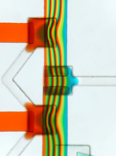 Three microvalves in a microchannel. The first and the third valve, leading to the orange-filled channel, are closed. The valve in the middle is open.