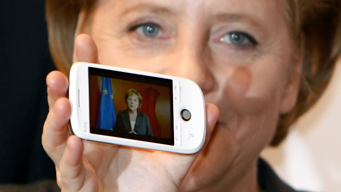 German Chancellor Angela Merkel holds a cell phone at the CeBIT in Hanover, March 3, 2009.