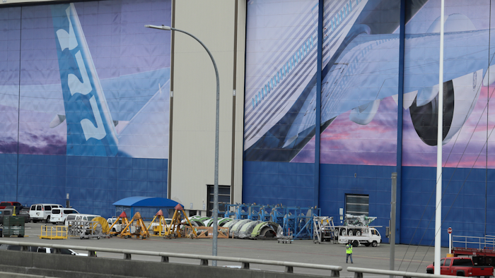 In this Monday, March 23, 2020, file photo, a worker walks near a mural of a Boeing 777 airplane at the company's manufacturing facility in Everett, Wash., north of Seattle.
