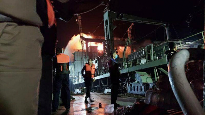 This photo made available by Asriran.com on Wednesday, June 2, 2021 shows personnel standing on Iran's navy support ship Kharg after being caught on fire in the Gulf of Oman. Kharg, the largest warship in the Iranian navy caught fire and later sank Wednesday in the Gulf of Oman under unclear circumstances, semiofficial news agencies reported.