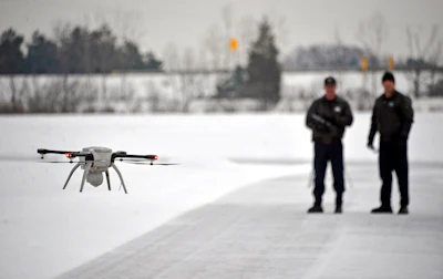 In this Jan. 15, 2015, file photo, Michigan State Police Sgt. Matt Rogers and Trooper Don Zinz bring an Aeryon SkyRanger drone in for a landing during a demonstration of the agency's new Unmanned Aircraft System at the Michigan State Police training track in Dimondale, Mich. More than a year after the U.S. Interior Department grounded hundreds of Chinese-made drones it was using to track wildfires and monitor dams and wildlife, the future of drone use by the federal government remains unmapped. The latest complication: Legislation moving through Congress that would block the U.S. government from using drones made in China.