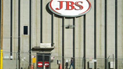 In this Oct. 12, 2020 photo, a worker heads into the JBS meatpacking plant in Greeley, Colo.