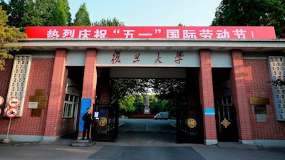 A security guard stands at the gate to the campus of Fudan University in Shanghai, April 28, 2017.