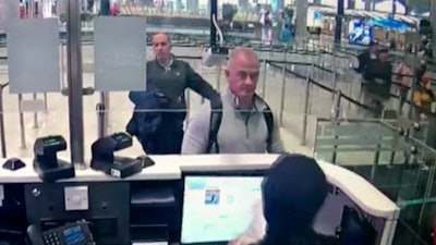 Image from security camera video showing Michael L. Taylor, center, and George-Antoine Zayek at passport control at Istanbul Airport, Turkey, Dec. 30, 2019.