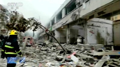 In this image taken from a video footage run by China's CCTV, a firefighter walks near the aftermath of a gas explosion in Shiyan city in central China's Hubei Province on Sunday, June 13, 2021. At least a dozen people were killed and more seriously injured Sunday after a gas line explosion tore through the residential neighborhood in central China.