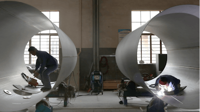 Workers perform welding on transport tanks at a factory in Nantong in eastern China's Jiangsu province Thursday, June 24, 2021.