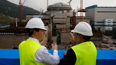 In this Oct. 17, 2013, file photo, then British Chancellor of the Exchequer George Osborne, left, chats with Taishan Nuclear Power Joint Venture Co. Ltd. General Manager Guo Liming as he inspects a nuclear reactor under construction at the nuclear power plant in Taishan, southeastern China's Guangdong province.