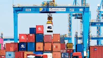 A gantry crane moves containers at a port in Qingdao in eastern China's Shandong province Friday, June 4, 2021. China's exports surged nearly 28% in May while imports jumped 51% as demand rebounded in the U.S. and other markets where the pandemic is waning, though growth is leveling off after a stunning recovery from last year's slump.