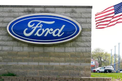 In this April 27, 2021 file photo, an American flag flies over a Ford auto dealership, in Waukee, Iowa. Ford’s outlook for the second quarter is improving, as the automaker is seeing strong customer reservations for four of its new vehicles. Ford Motor Co. now anticipates, Thursday, June 17, its quarterly adjusted earnings before interest and taxes to top its expectations and be significantly better than the year-ago period.