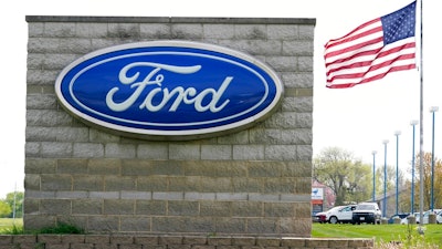 In this April 27, 2021 file photo, an American flag flies over a Ford auto dealership, in Waukee, Iowa. Ford’s outlook for the second quarter is improving, as the automaker is seeing strong customer reservations for four of its new vehicles. Ford Motor Co. now anticipates, Thursday, June 17, its quarterly adjusted earnings before interest and taxes to top its expectations and be significantly better than the year-ago period.