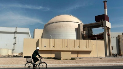 In this Oct. 26, 2010 file photo, a worker rides a bicycle in front of the reactor building of the Bushehr nuclear power plant, just outside the southern city of Bushehr. Iran’s sole nuclear power plant has undergone a temporary emergency shutdown, state TV reported on Sunday, June 20, 2021.