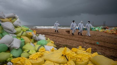 Sri Lankan navy soldiers walk on the beach looking for plastic debris washed ashore from fire damaged container ship MV X-Press Pearl at Kapungoda, on the outskirts of Colombo, Sri Lanka. Monday, June 14, 2021.