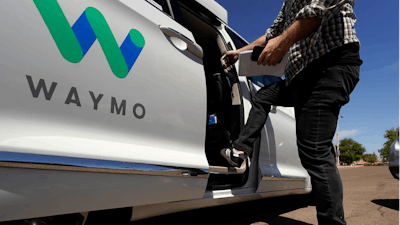 In this April 7, 2021 file photo, a Waymo minivan arrives to pick up passengers for an autonomous vehicle ride, in Mesa, Ariz. Waymo, the self-driving car pioneer spun off from Google, isn't allowing a recent wave of executive departures to detour its plans to expand its robotic taxi service.