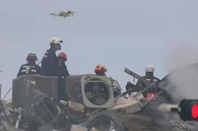A drone flies above search and rescue personnel at the site of the Champlain Towers South Condo building collapse in Surfside, Florida.