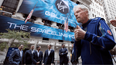 In this Monday, Oct. 28, 2019 file photo, Richard Branson, right, founder of Virgin Galactic, and company executives gather for photos outside the New York Stock Exchange before his company's IPO. Branson announced Thursday, July 1, 2021 he plans to fly into space this month on the next test flight of his Virgin Galactic rocket ship. The launch window will open July 11.
