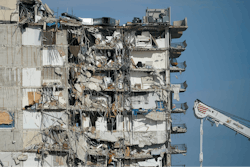 A parked crane sits beside the still standing section of Champlain Towers South, which partially collapsed last Thursday, as rescue efforts on the rubble below were paused out of concern about the stability of the remaining structure, Thursday, July 1, 2021, in Surfside, Fla. Scores of residents are still missing one week after the seaside condominium building partially collapsed.