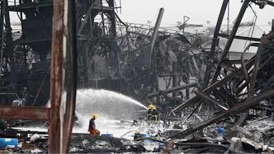 Firefighters spray foam amid twisted metal frames of a charred chemical factory Tuesday, July 6, 2021 in Samut Prakan, Thailand.Firefighters finally extinguished a blaze at a chemical factory just outside the Thai capital early Tuesday, more than 24-hours after it started with an explosion that damaged nearby homes and then let off a clouds of toxic smoke that prompted a widespread evacuation.