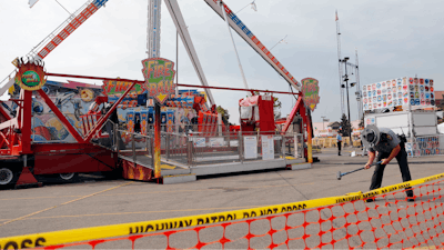 In this July 27, 2017 file photo, an Ohio State Highway Patrol trooper removes a ground spike in front of the Fire Ball ride at the Ohio State Fair, in Columbus, Ohio. Ohio has beefed up its amusement ride inspections four years after the ride broke apart at the 2017 Ohio State Fair and killed a high school student and injured several others. But some ride operators and festival organizers say the state's inspectors are overreaching and shutting down rides over issues that aren't safety-related.