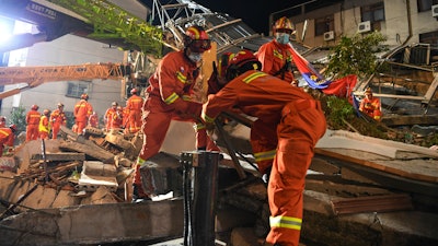 In this photo released by Xinhua News Agency, rescuers prepare equipment as they search for survivors at a collapsed hotel in Suzhou in eastern China's Jiangsu Province on Monday, July 12, 2021. The hotel building collapsed Monday afternoon.