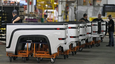 In this June 22, 2021, file photo, employees stand near Endurance truck beds during a media tour of the Lordstown Motors complex in Lordstown, Ohio. Lordstown Motors, an Ohio company that has come under scrutiny over the number of orders it claimed it had for the electric trucks that it wants to produce, acknowledged that it has received two subpoenas from federal regulators and that prosecutors in New York have opened an investigation.