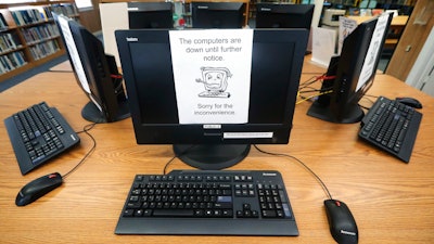 In this Aug. 22, 2019, file photo, signs on a bank of computers tell visitors that the machines are not working at the public library in Wilmer, Texas. The Associated Press has learned new details about a ransomware attack that affected roughly two dozen Texas communities two years ago.