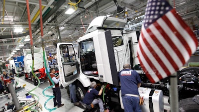 In a Jan. 6, 2011, file photo, workers install parts on a truck on the Volvo truck assembly line at the Volvo plant in Dublin, Va.