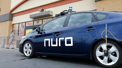 A self-driving Nuro vehicle parks outside a Fry's supermarket, Scottsdale, Ariz., Aug. 16, 2018.
