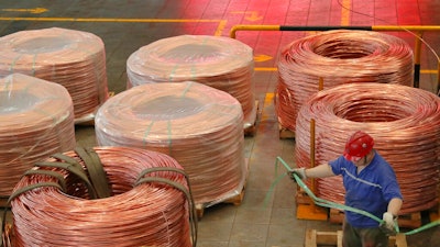 A man works at a factory producing power grid equipment and cable in Nantong city in east China's Jiangsu province Tuesday, July 27, 2021. China's manufacturing growth in July slowed to its lowest level in 15 months as export demand weakened and factories coped with disruptions in supplies of raw materials and components, two surveys found.